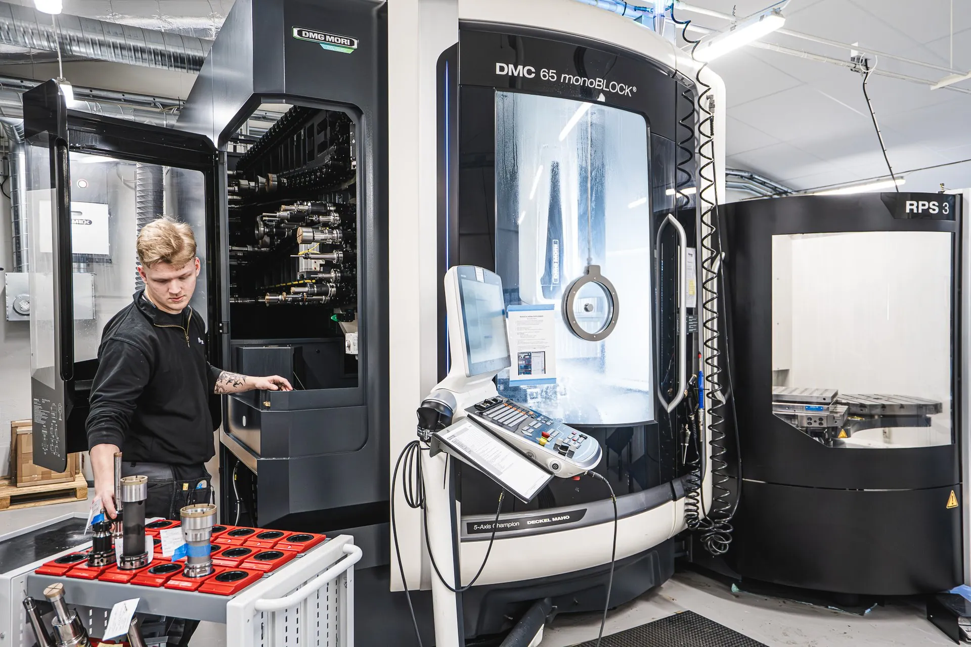 Operator picking tools from a tool trolley by the tool magazine of a DMC 65 monoBLOCK
