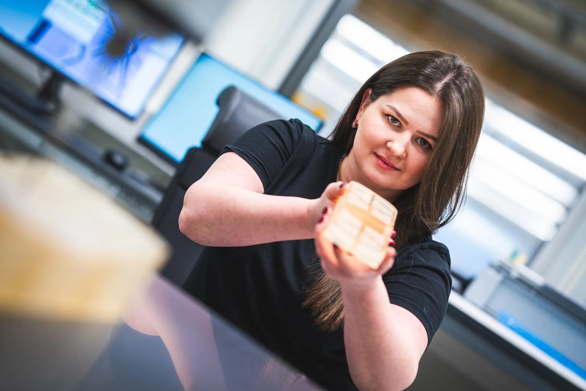 Employee holding a lightweight-machined part with a ribbed structure towards the camera
