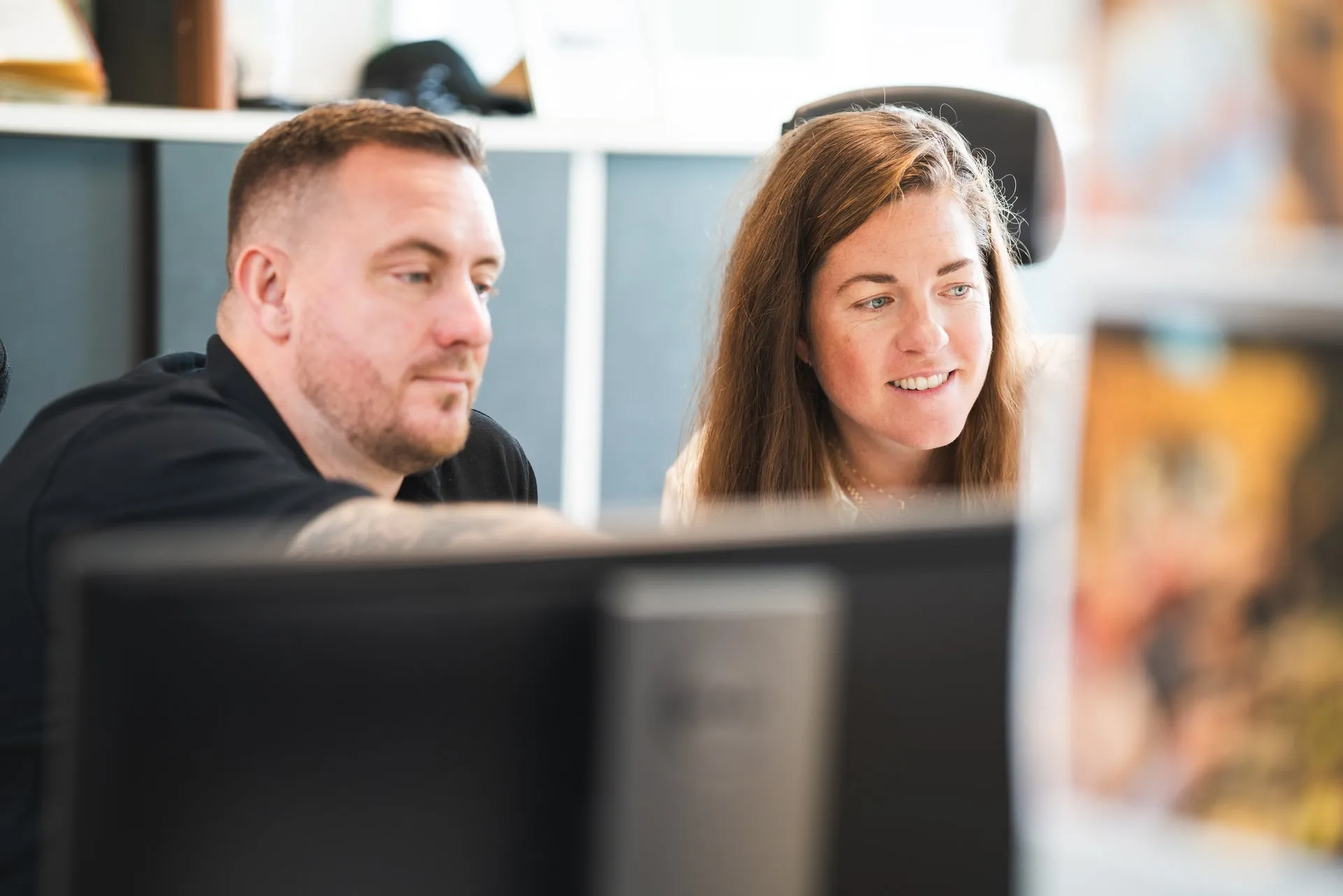 Two colleagues looking at a screen together in the office
