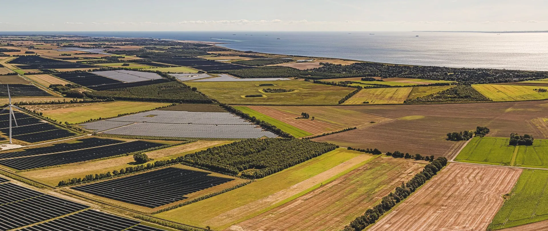 Panorama över solparkens fält ner mot kusten