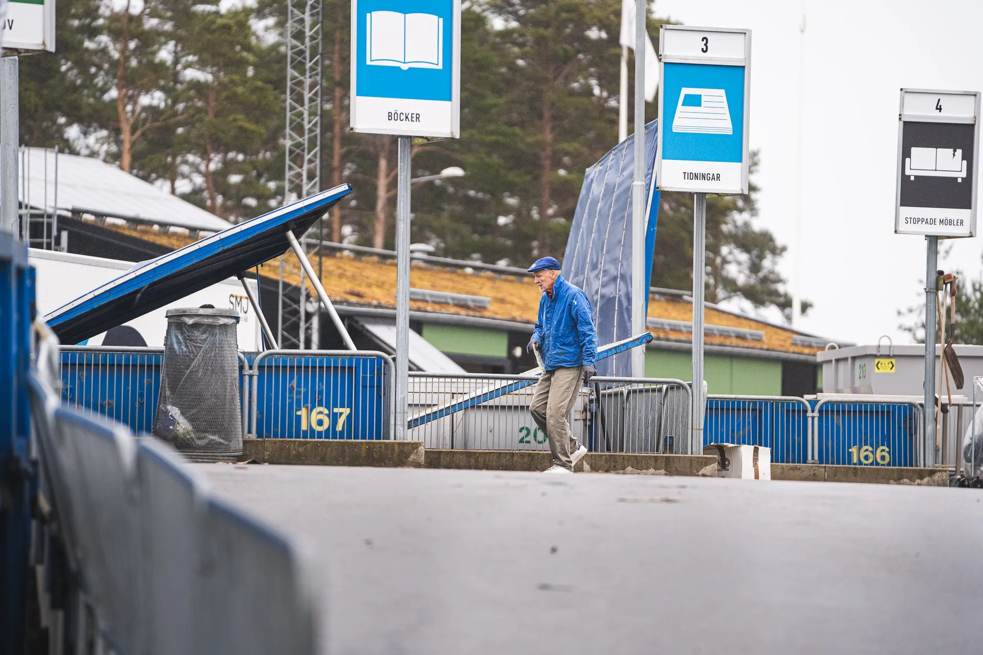 Närbild på baklastare som tömmer ett kärl med trädgårdsavfall