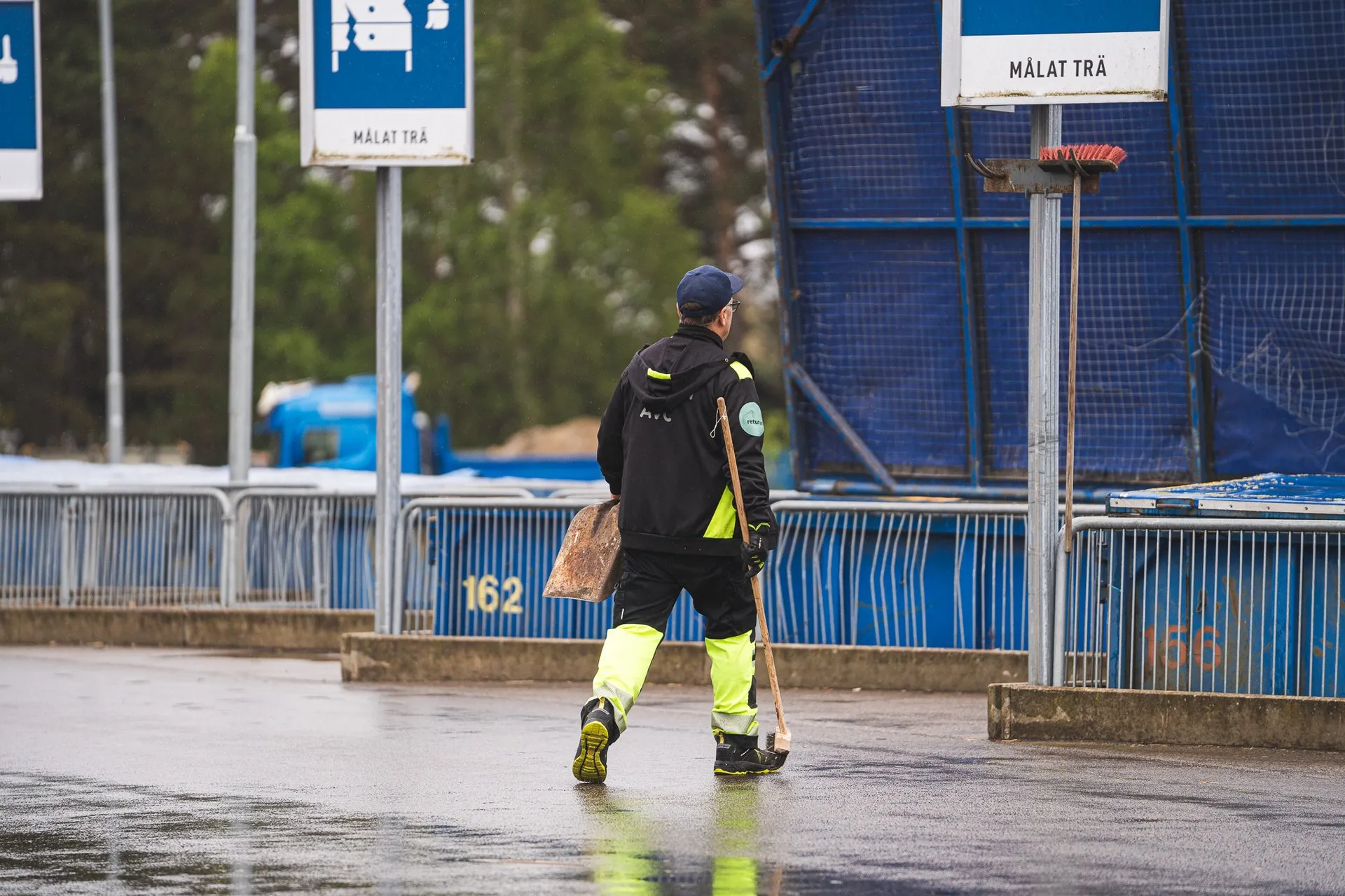 Grön Renhållningen-bil parkerad framför kontoret med företagets logotyp