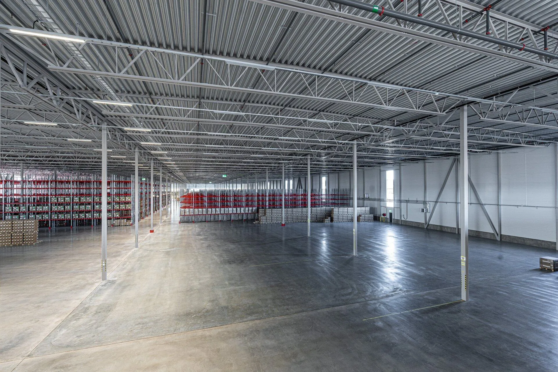 Interiör av storskalig lagerhall med pallställage och högt tak