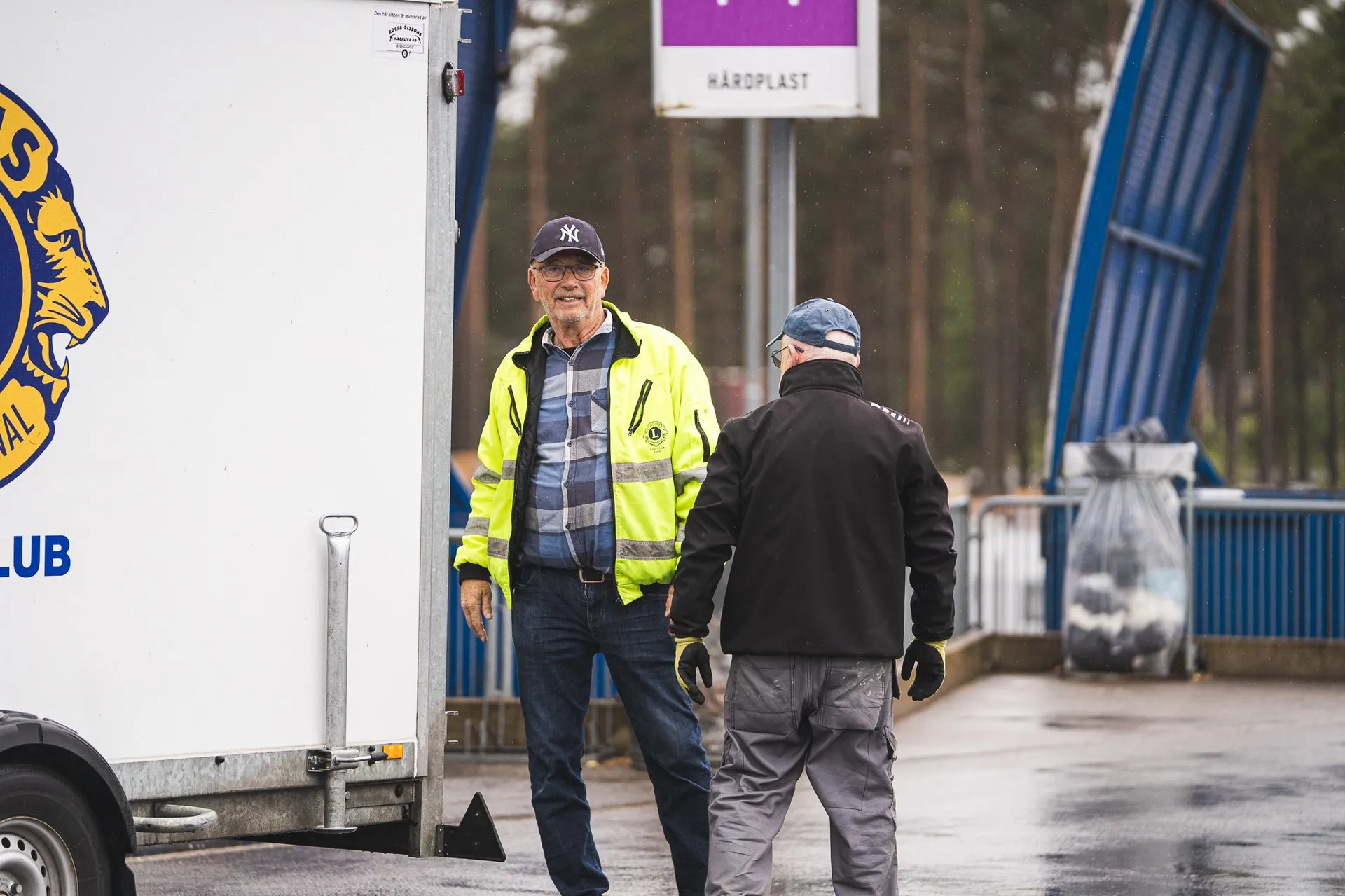 Chaufför stiger ur hytten på en sopbil i tidig morgonljus