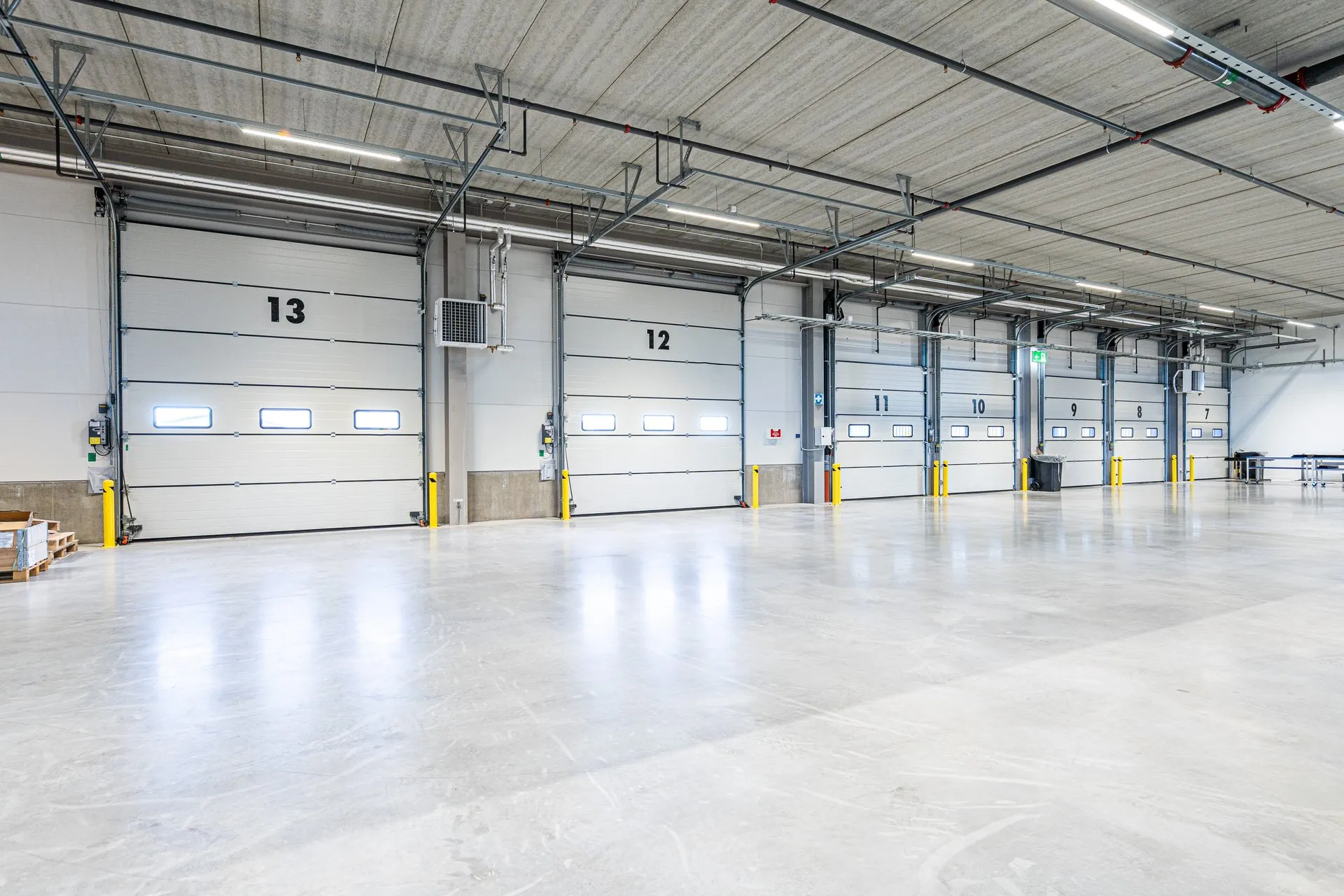 Rad av numrerade lastportar i nybyggd logistikbyggnad