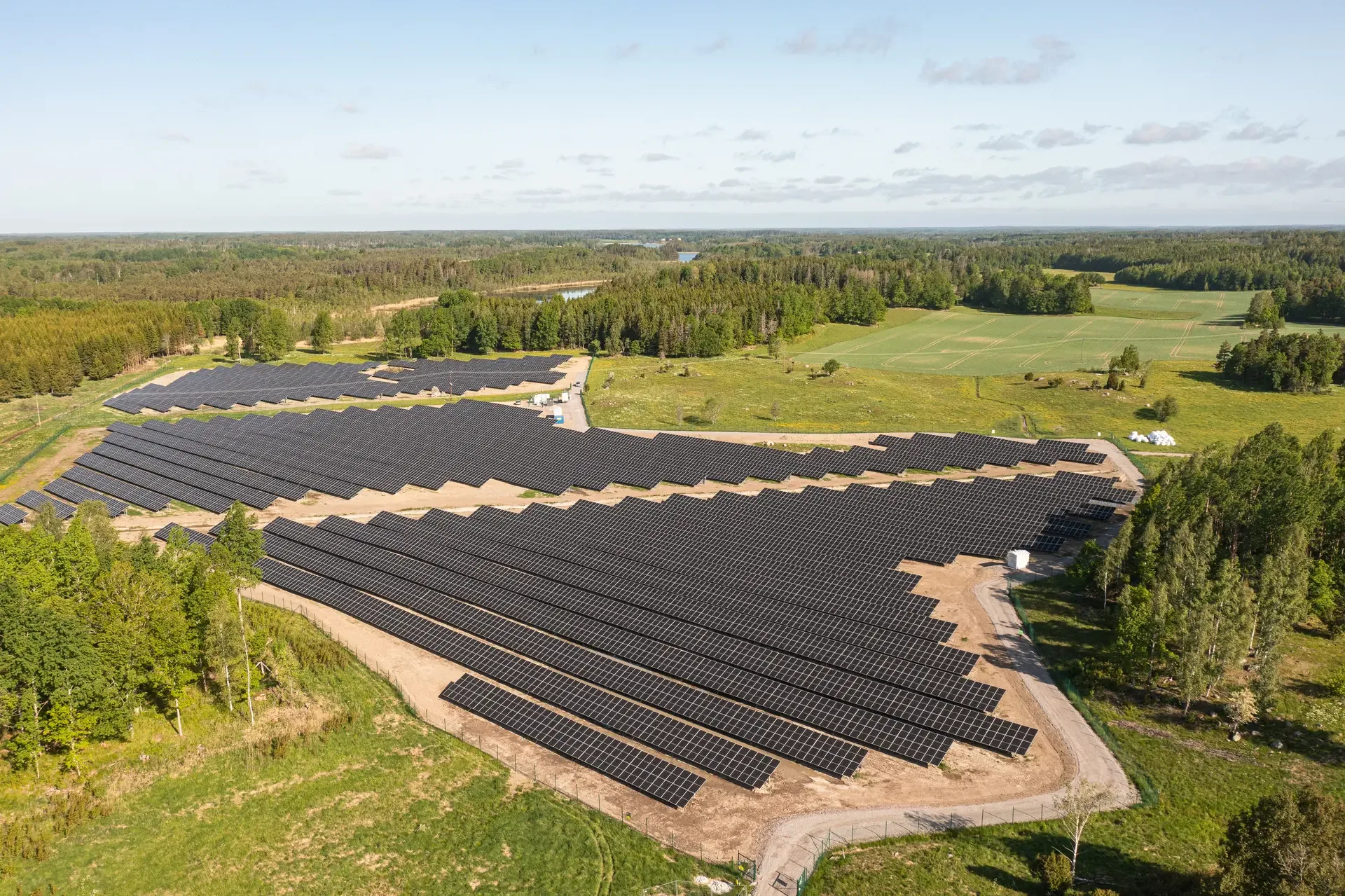Flygfoto över panelraderna i Chara-park, Katrineholm, med skog och sjö i bakgrunden