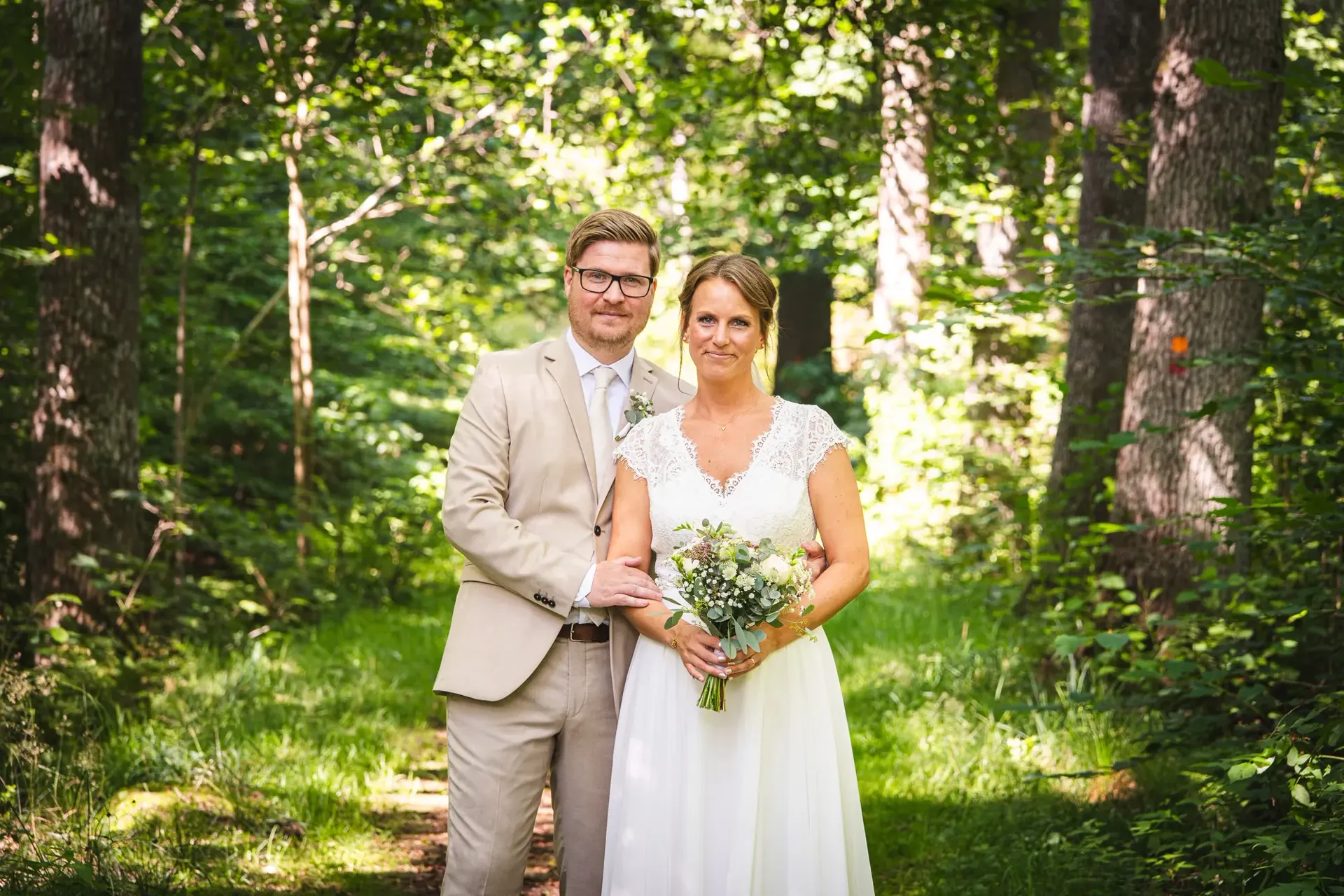 Brudparet med brudbukett i sommargrön skog utanför Hässleholm